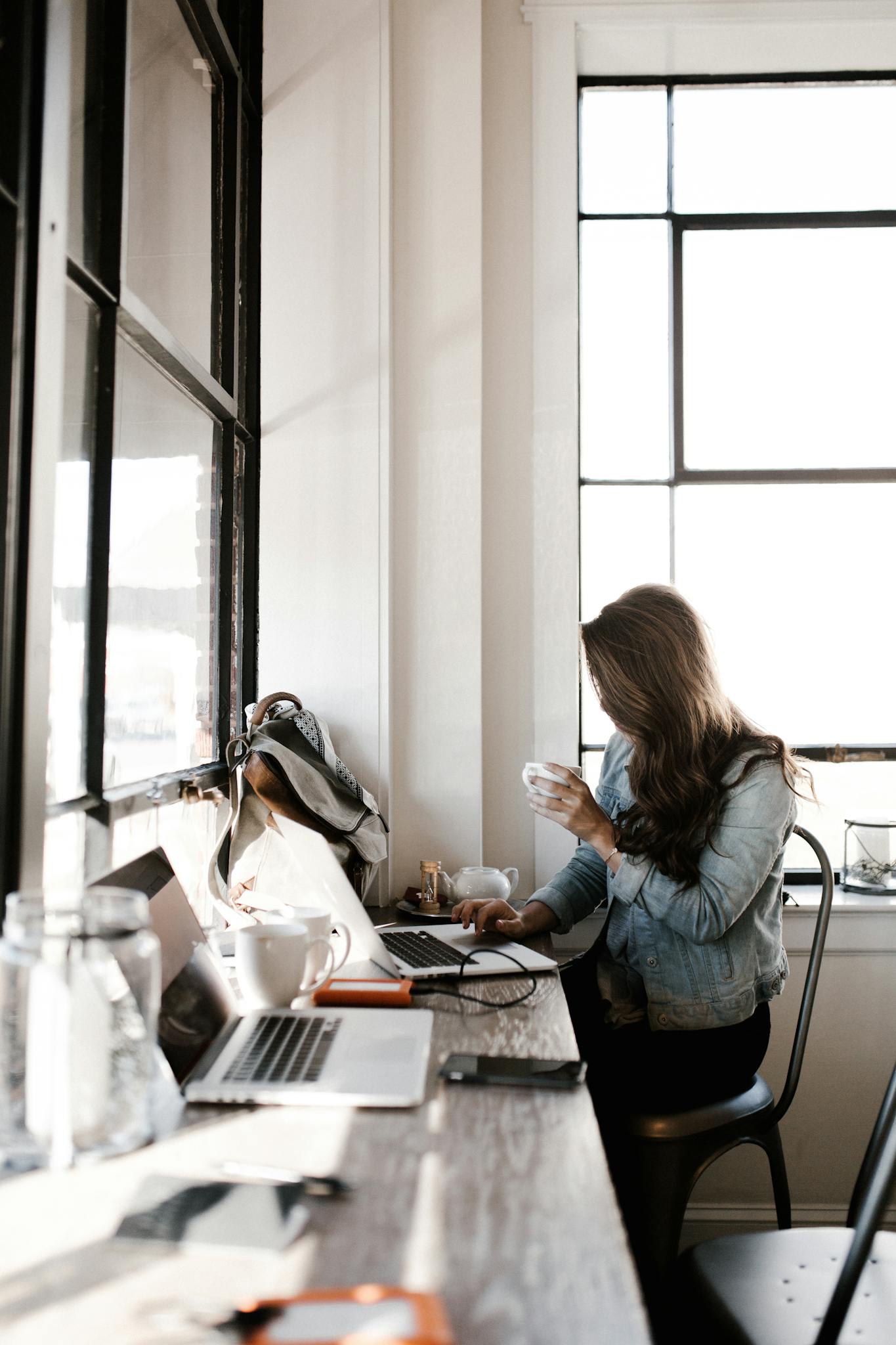 woman in gray jacket sitting beside desk